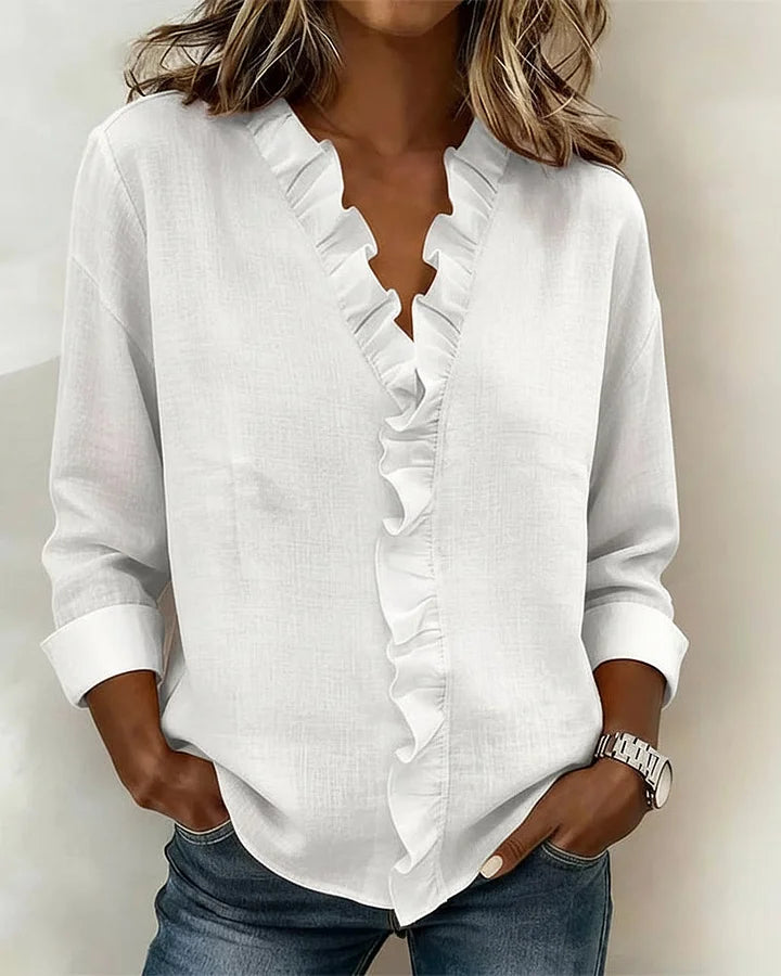Close-up detail of the ruffled V-neckline on the Persephone blouse, highlighting texture and stitching.