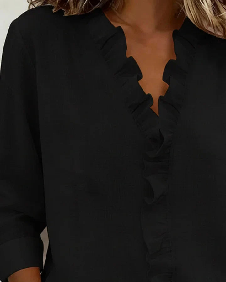 Rear view of the Persephone ruffled V-neck blouse in blue, showcasing the back detail and drape.