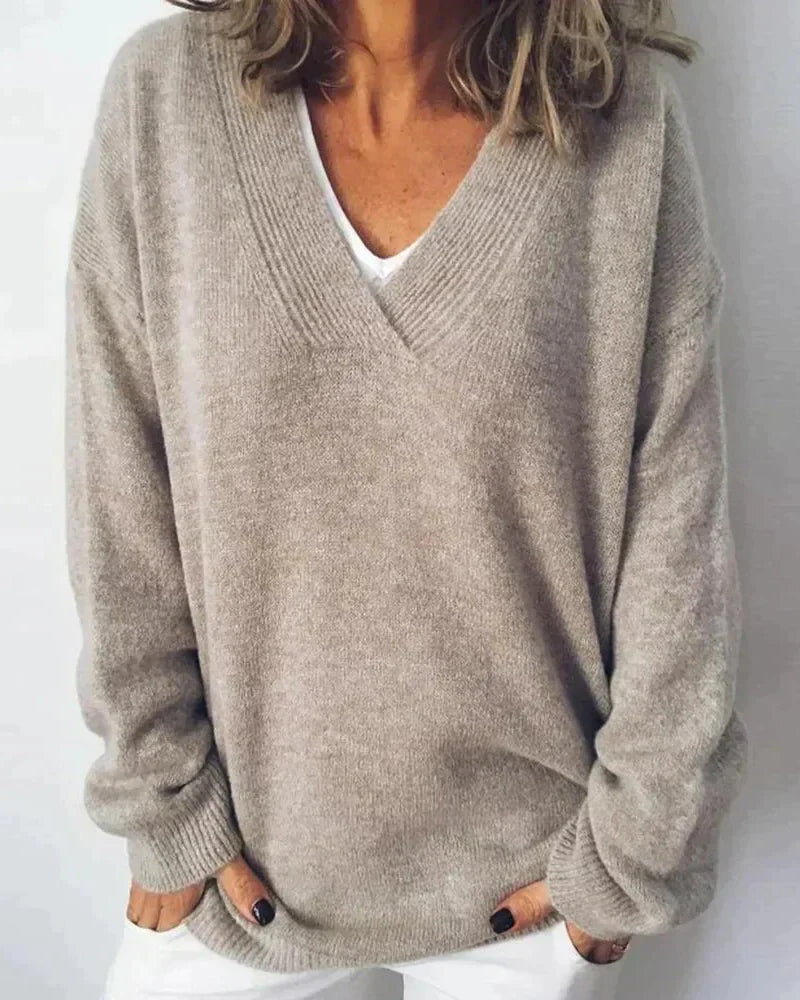 Front view of a woman wearing a beige cashmere knit sweater, showcasing its relaxed fit and soft texture.