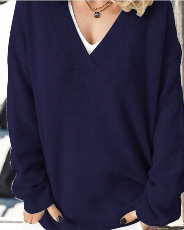Close-up detail of the luxurious cashmere knit sweater fabric in black, highlighting the fine texture.