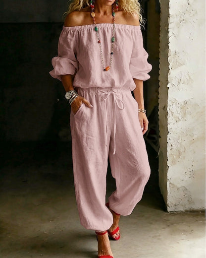 Front view of a model wearing a black Seraphina cotton off-shoulder jumpsuit, exuding sophisticated casualness.
