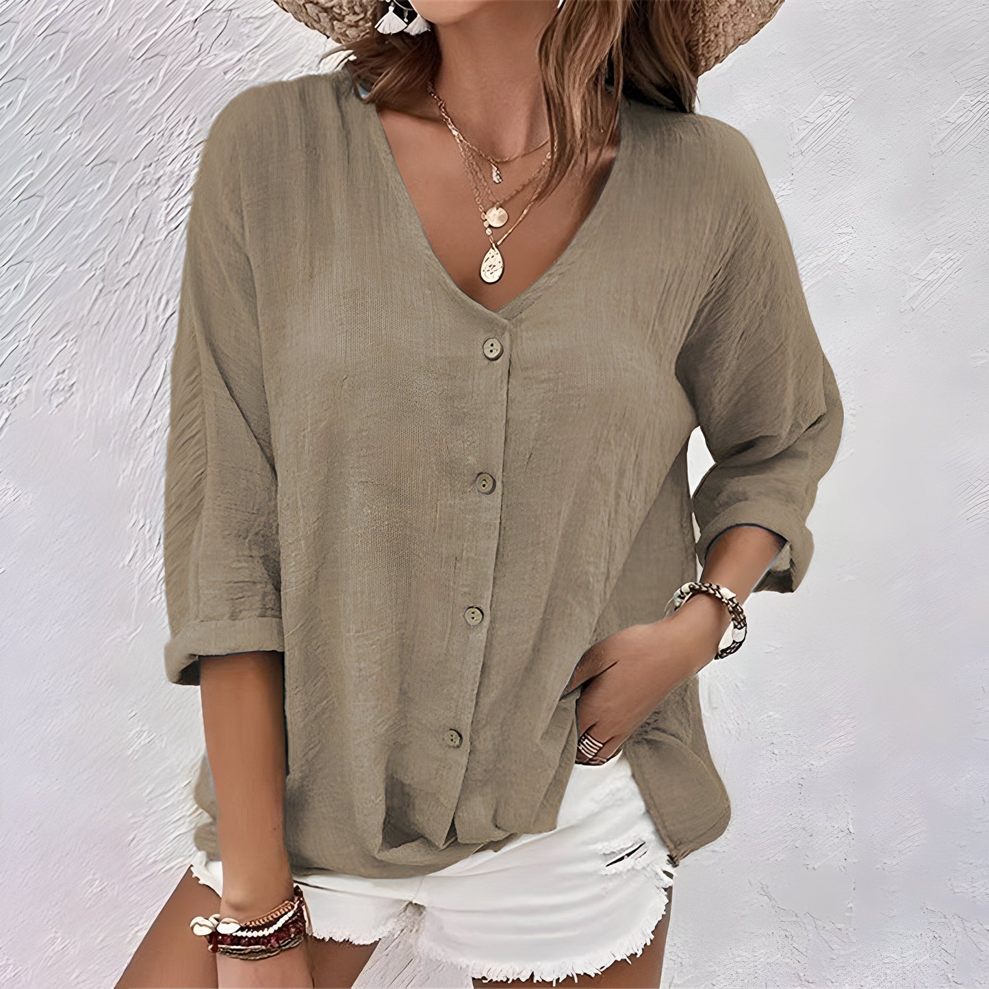 Model wearing the versatile button-up blouse in khaki, styled casually with trousers for a daytime look.