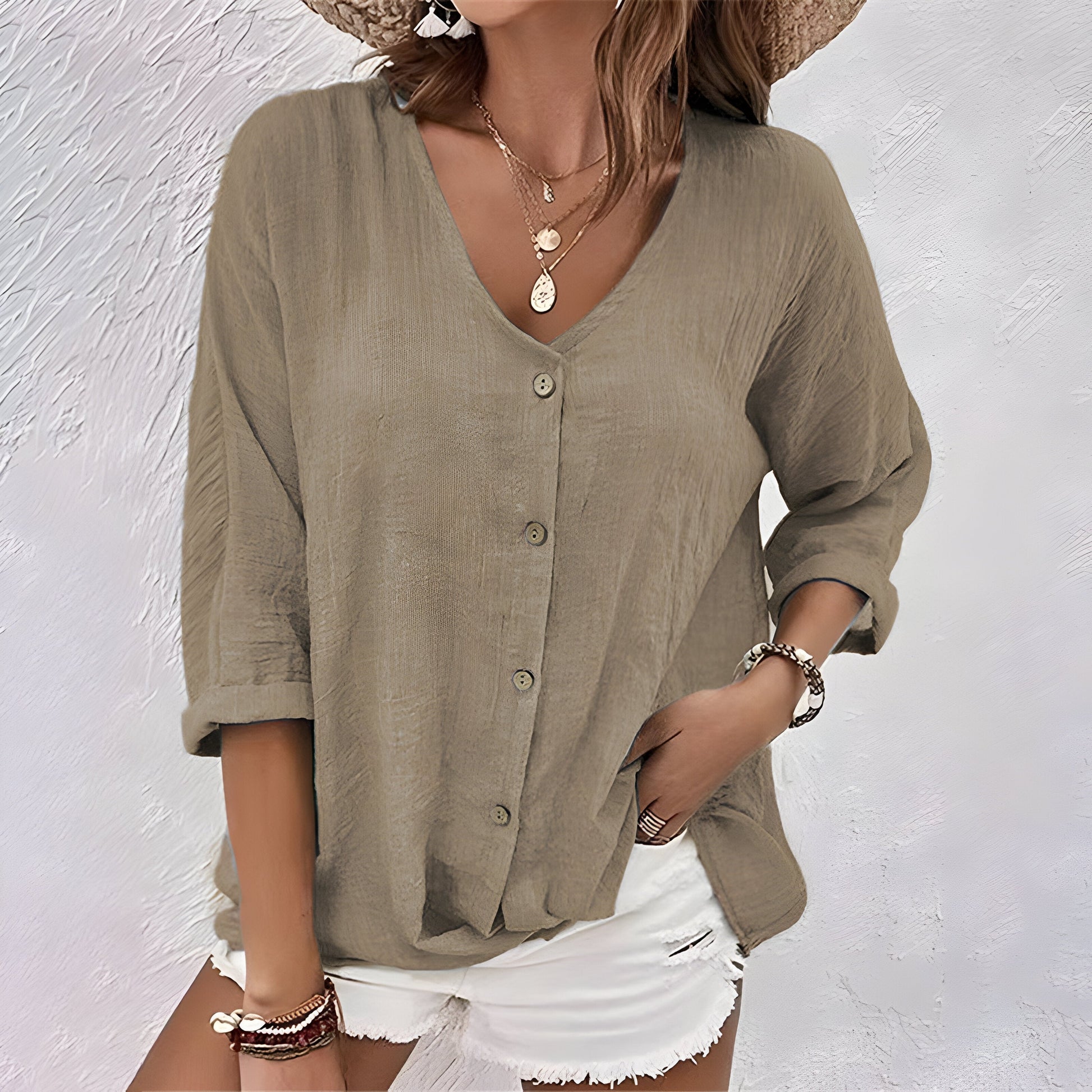 Model wearing the versatile button-up blouse in khaki, styled casually with trousers for a daytime look.