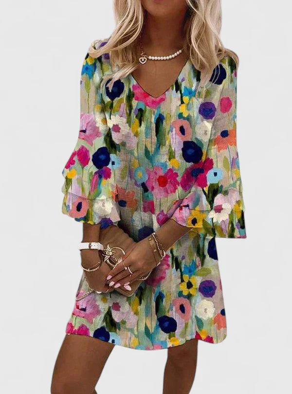 Front view of the vibrant floral mini dress, showcasing its intricate pattern and V-neckline in a bright setting.