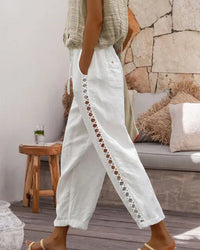 Detail shot of the pocket and waistline of the stylish hollow-out linen trousers.