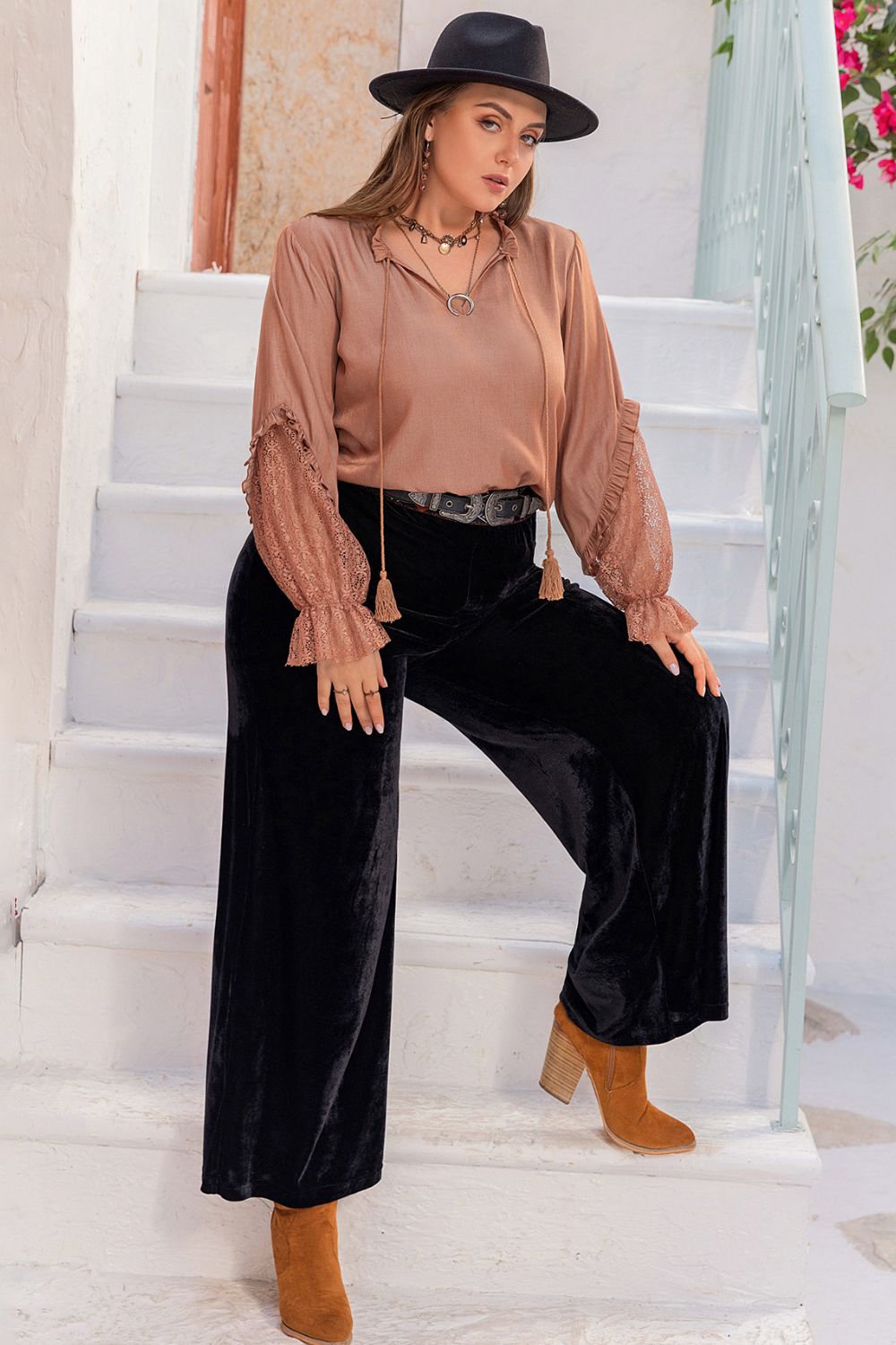 Lifestyle image of the Solana plus size tie neck blouse styled for an urban setting, paired with accessories.