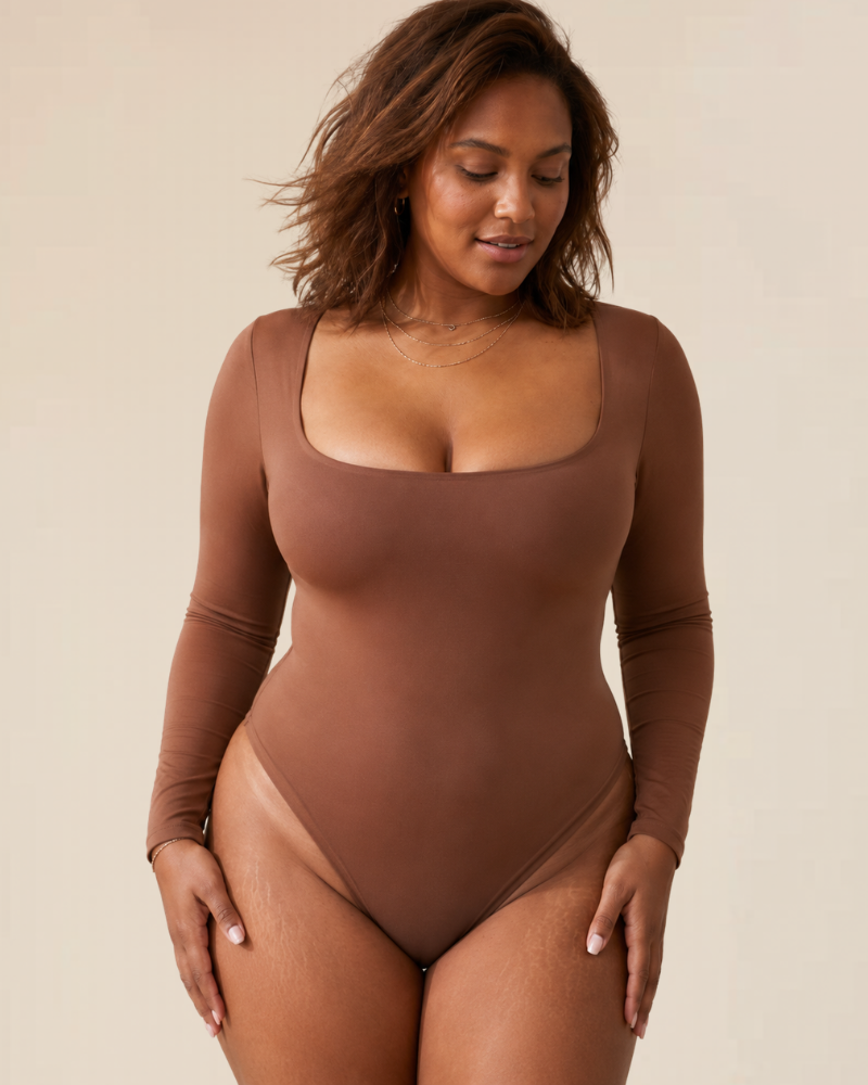 Close-up detail of the popper fastening at the bottom of a brown long sleeve thong bodysuit, ensuring a secure fit.