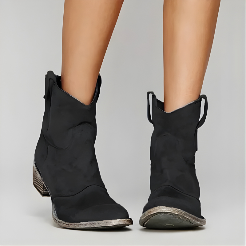 Full-view of a black Solene Western ankle boot, highlighting the stacked heel and smooth leather texture against a neutral backdrop.