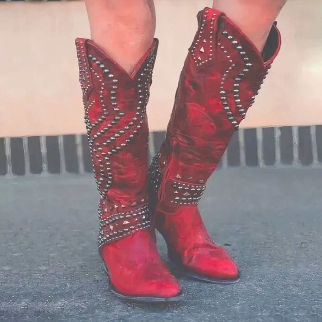 A model wearing red Rhiannon knee-high western boots, styled with a flowing dress for an elevated look.