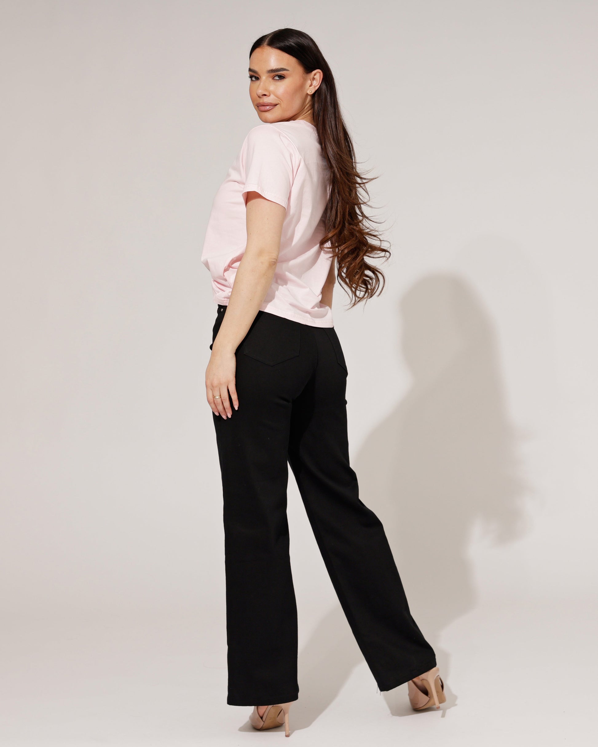 Model wearing the Thalassa black wide-leg jeans with a tucked-in top, styled for a chic, urban look.