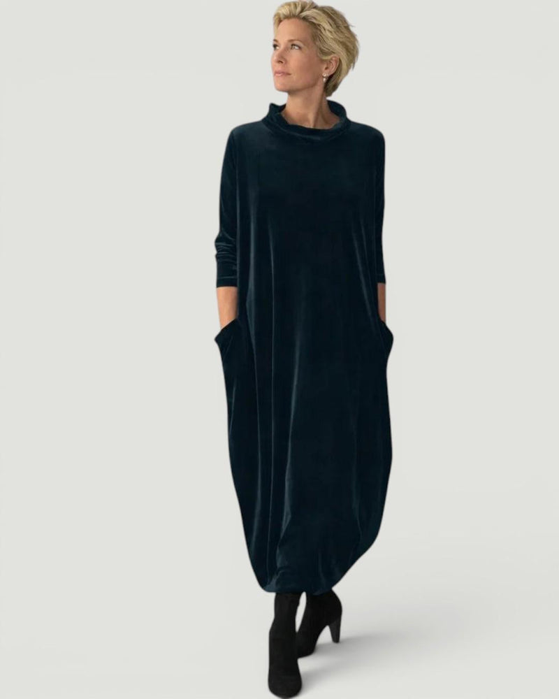 Front view of the elegant Yara velvet maxi dress in dark green, showcasing its loose draped silhouette.