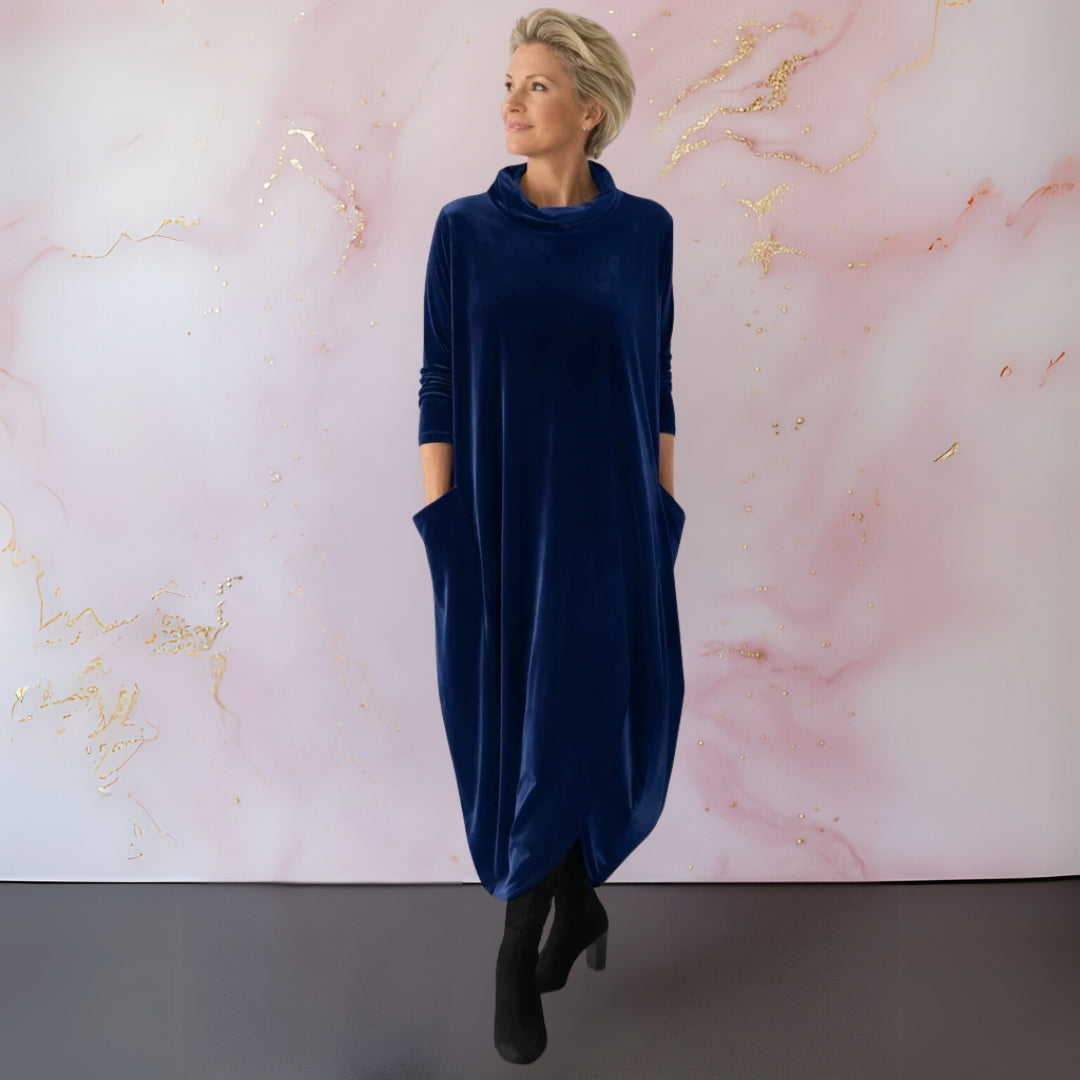 Side profile of a woman wearing the blue Yara velvet maxi dress, illustrating its graceful flow.